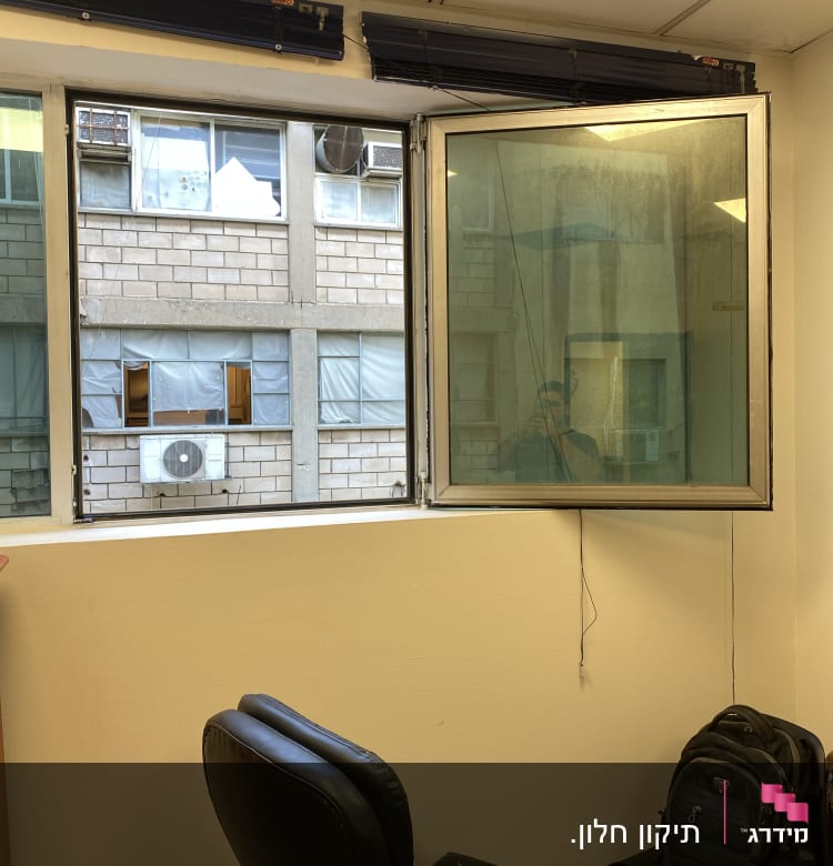 תריסים פתוחים מעל חלון זכוכית במשרד